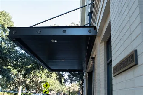 Building entrance with metal canopy and trees.