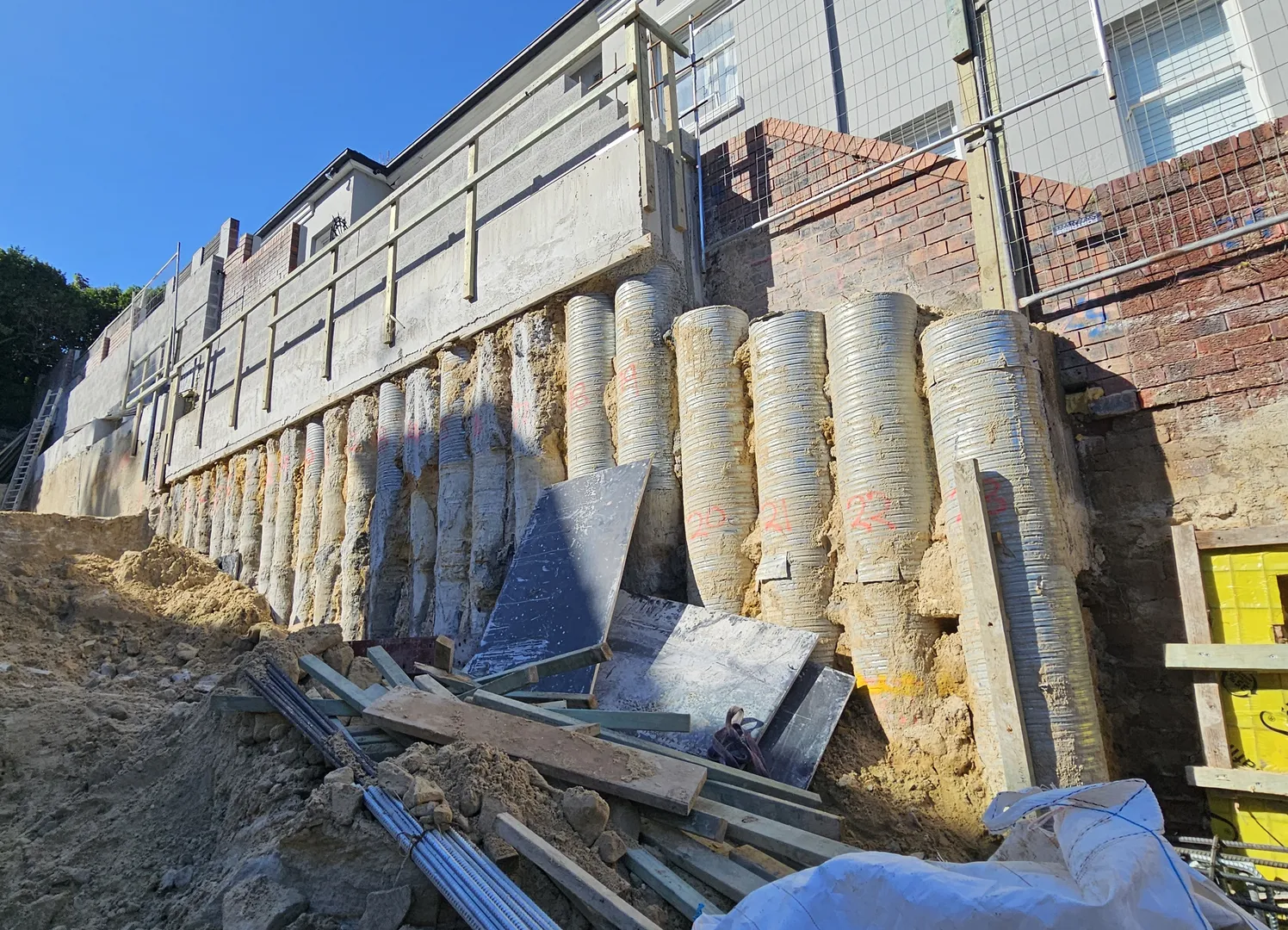 Construction site with retaining wall and equipment.